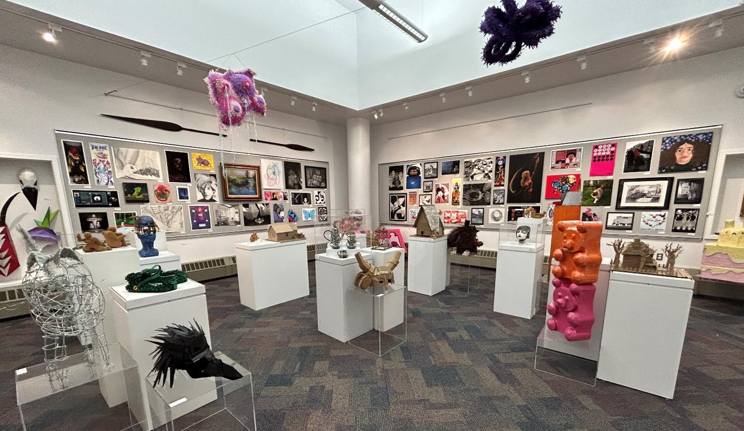 A colorful photo of an art gallery that displays art projects in the forms of 3D, 2D, photography, ceramics and design.