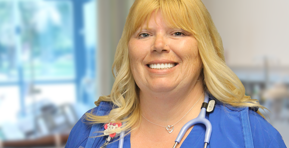 Dee Patterson in nursing uniform standing in nursing skills lab