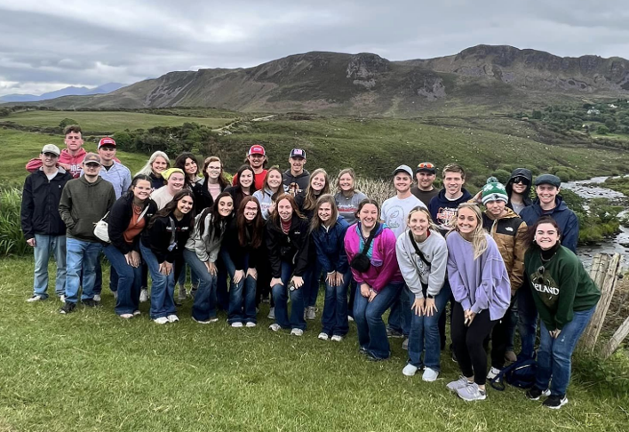 LLCC Ag students posing for a photo on top of a green hillside in Ireland.