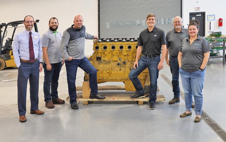 Dr. Jason Dockter, Kody Letterle, Nick Johnson, Keith Heiar, Jeff Gardner and Dr. Nancy Sweet standing by one of the donated engines.