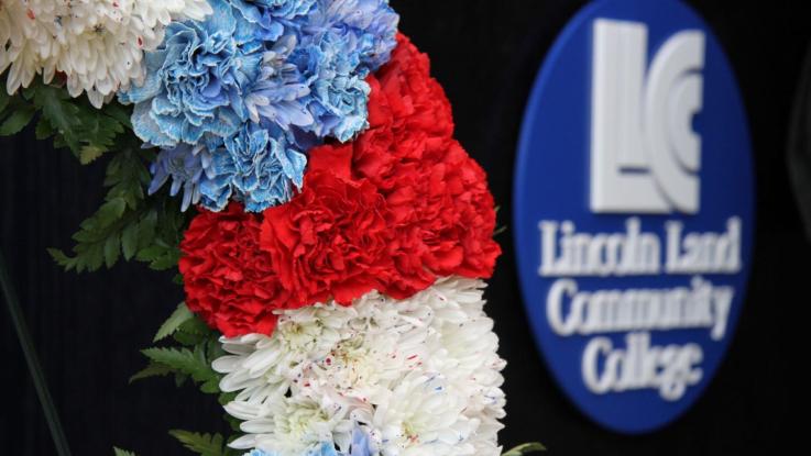 A wreath in front of the Lincoln Land Community College logo.