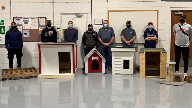 Students in the Structural Carpentry Concepts class pose for a photo with their doghouses and cat perches.