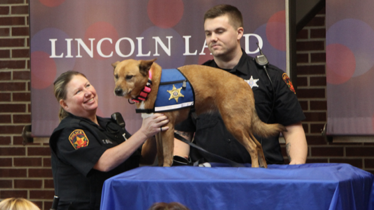 LLCC Police Officers Tammy Baehr and Scott McDermand with Pawfficer Ember at her swearing in ceremony.