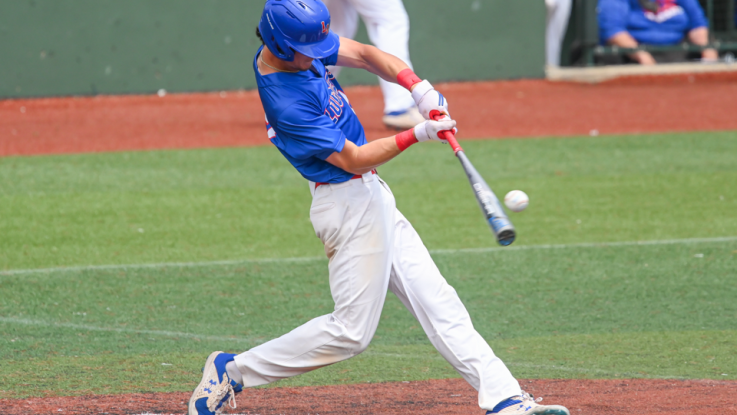 LLCC baseball player hits baseball with baseball bat