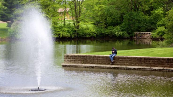 Student sitting by Lake Macoupin on LLCC's campus