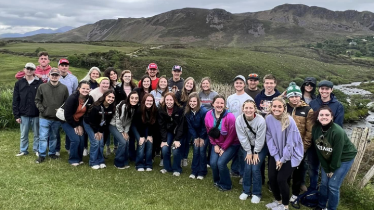 LLCC Ag students posing for a photo on top of a green hillside in Ireland.