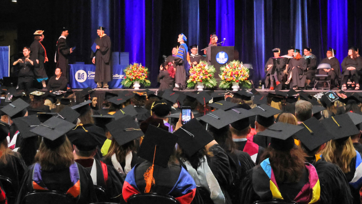 2023 LLCC Commencement graduate caps and stage.