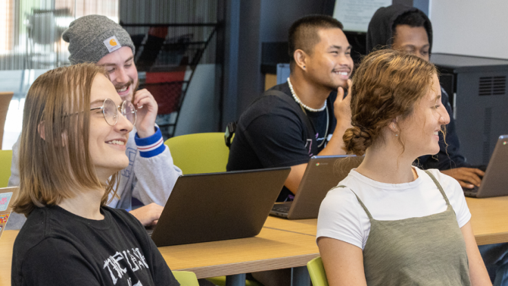 Students sitting in a classroom and smiling