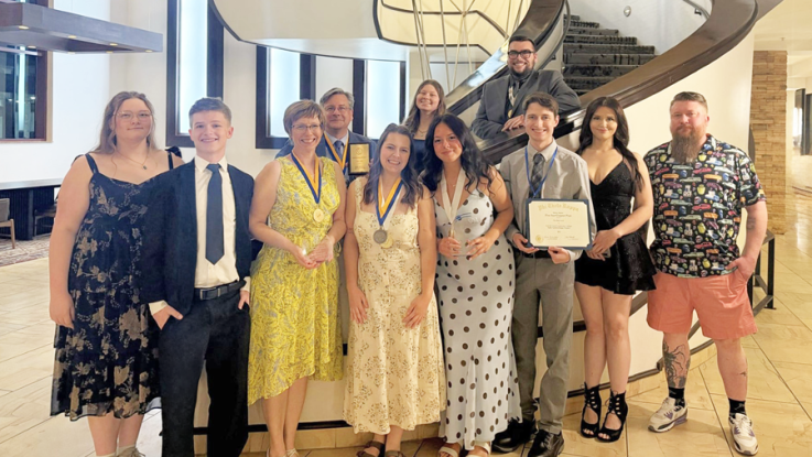 PTK students pose near a staircase