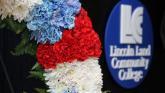A wreath in front of the Lincoln Land Community College logo.