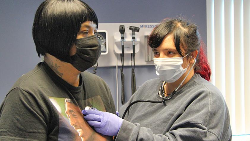 student wearing mask checking heart rate of patient wearing mask