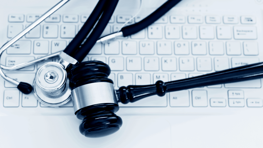 stethoscope and gavel laying on computer keyboard