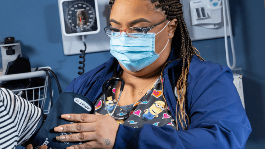 student taking patient's blood pressure