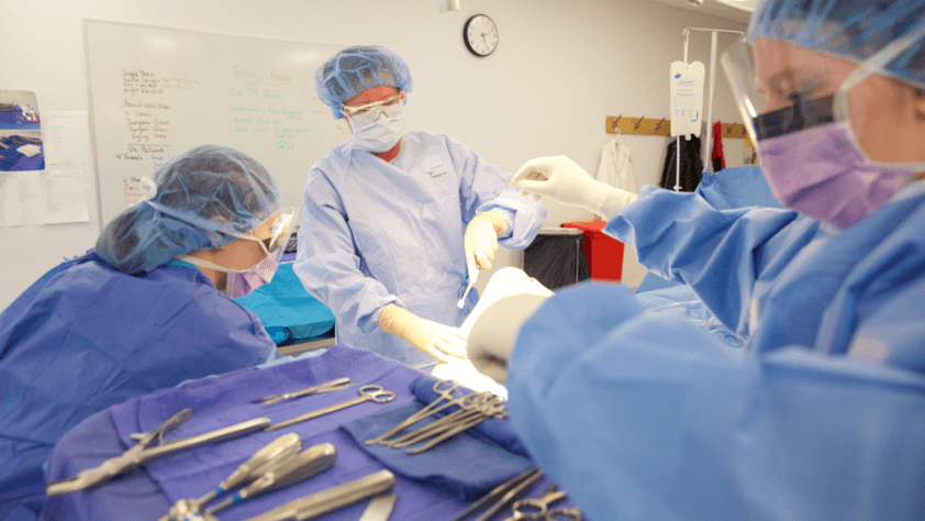 students practicing surgical technology techniques in a surgical setting classroom