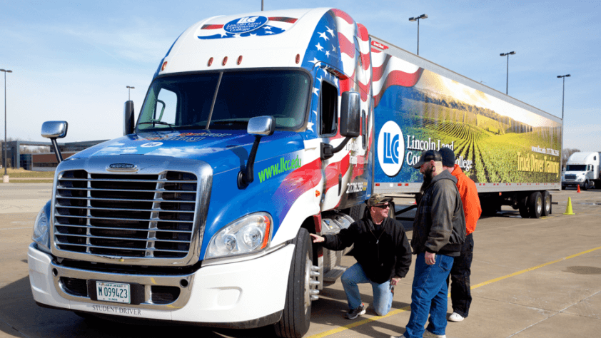 Students check a tire of one of LLCC's trucks.