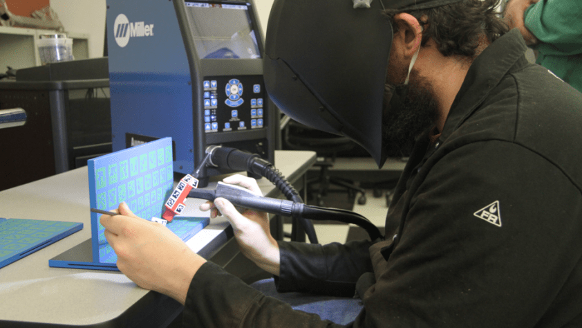A student practices welding in a lab.