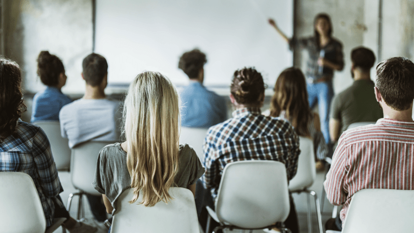 Students seated in a classroom listening to presenter