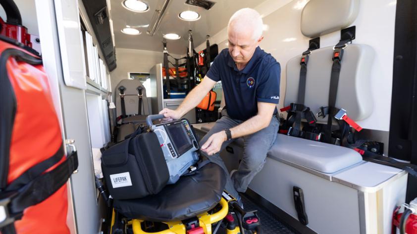 instructor inside an ambulance checking equipment