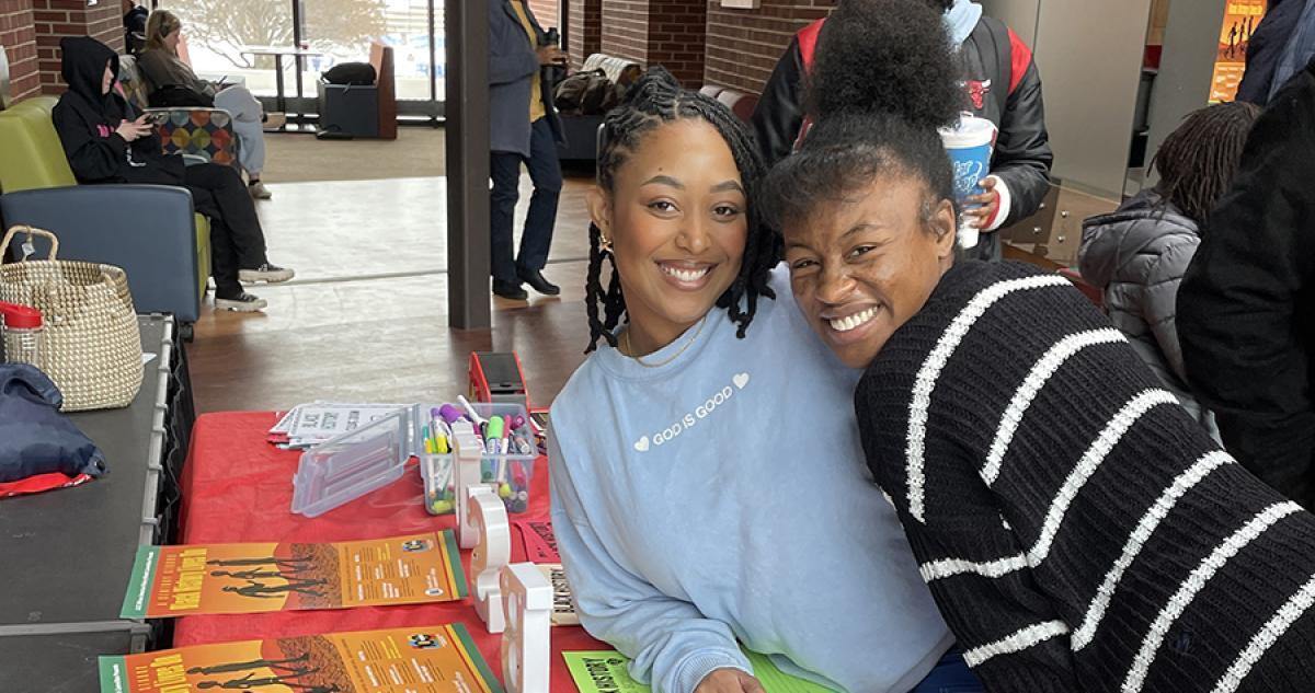 Two students smiling at the camera and posing during a student event.