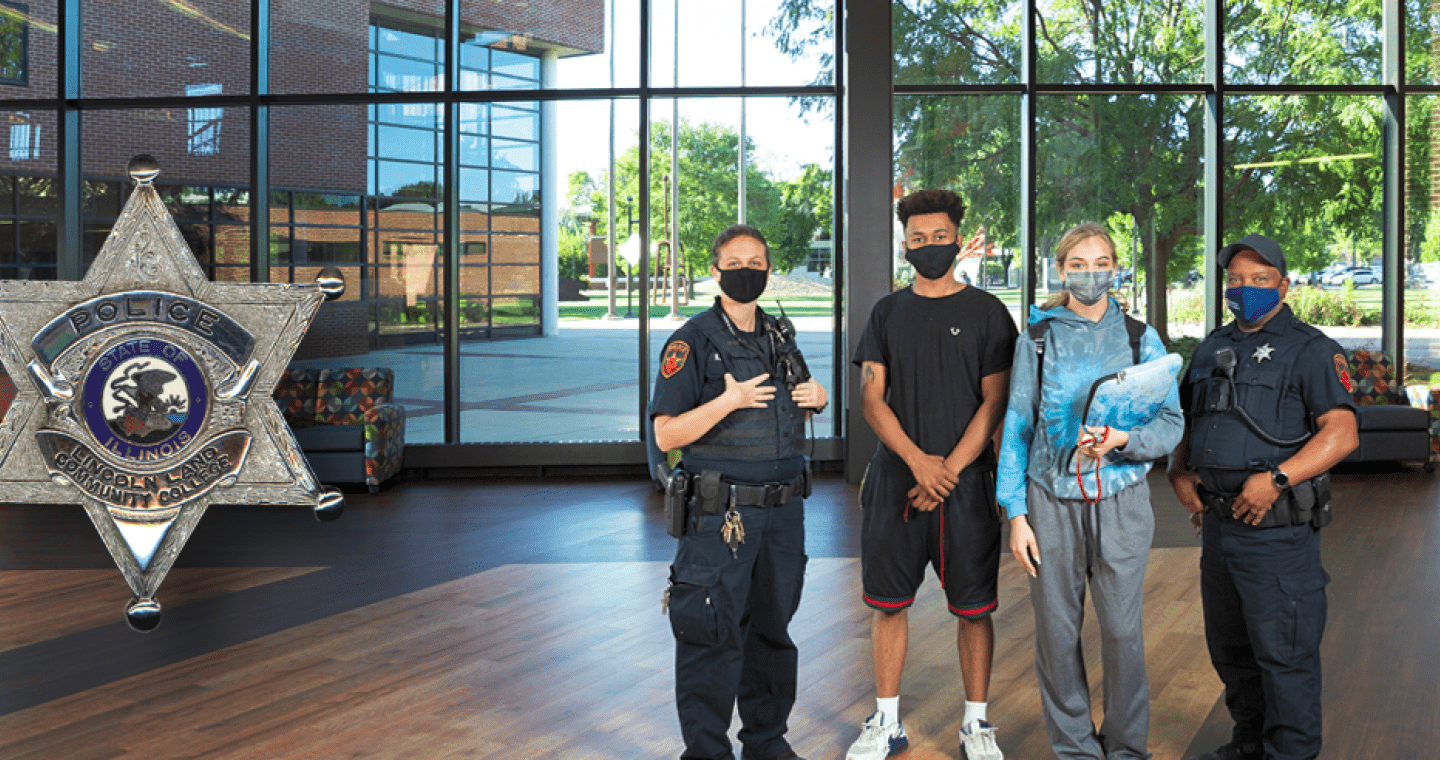 Two LLCC Police Department officers standing with two students in A. Lincoln Commons