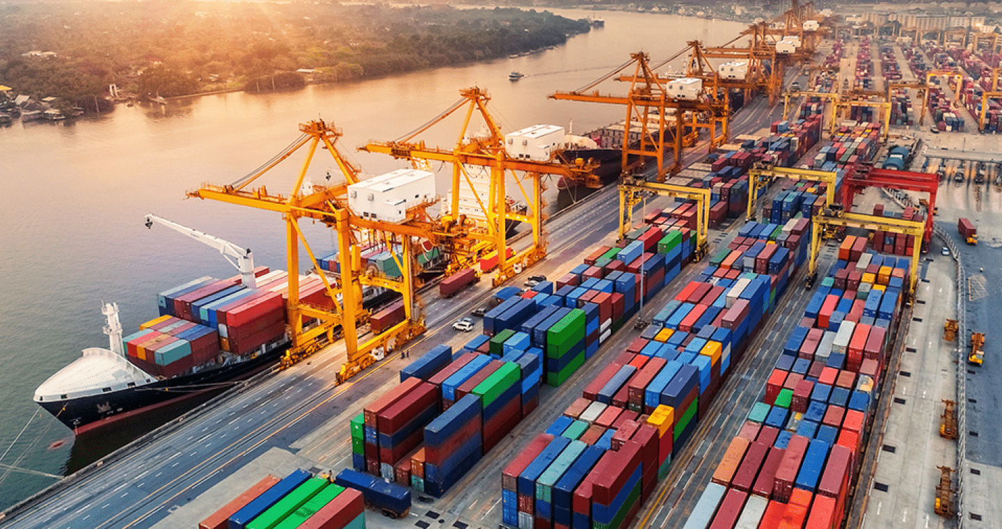 freight ship at a shipping yard with a lot of shipping containers on the dock