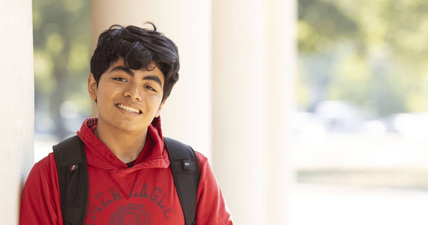 Student with a red sweatshirt and backpack