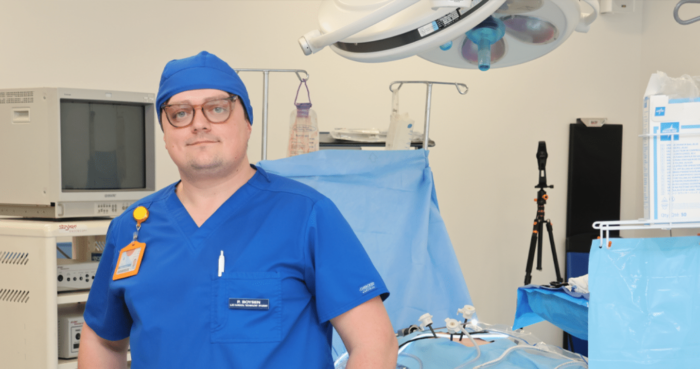 male in blue scrubs standing in an operating room