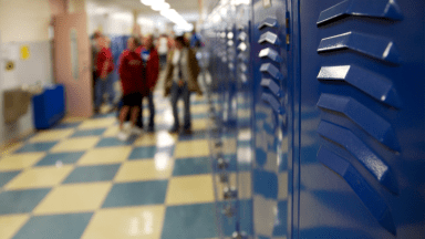 Hallway in high school with lockers and students talking