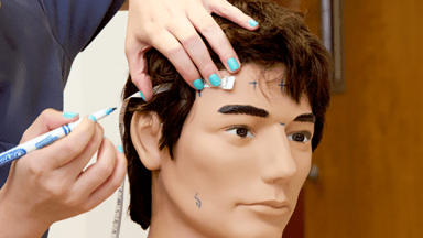 student taking measurements of a maniken's head