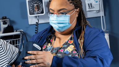 student taking patient's blood pressure