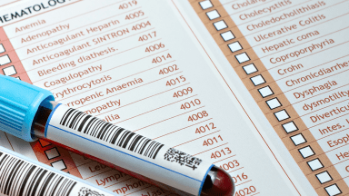 tube of blood sitting on top of a list of medical terms with the codes