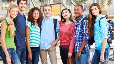 Group of seven, diverse young people with backpacks