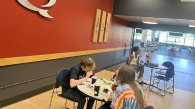 Students eating lunch at tables in Quiznos