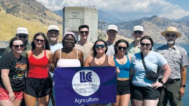 students in front of a dam holding a Lincoln Land Community College Agriculture banner
