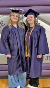 Two students in graduation gowns