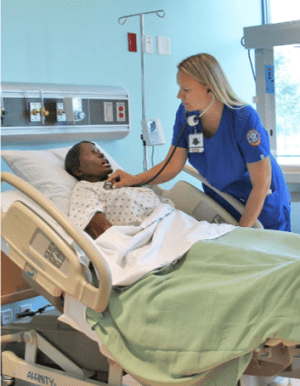 Dee Patterson using a stethoscope in nursing skills lab