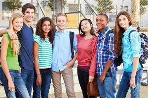 Group of seven, diverse young people with backpacks