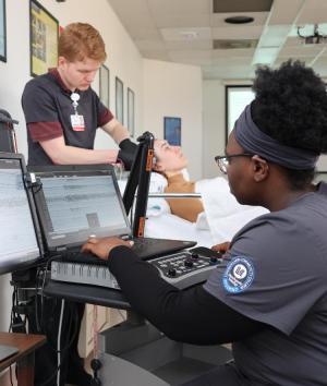 Students practicing medical skills in a classroom.