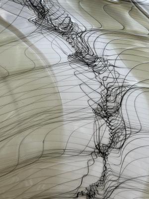 Glass art with black flowing lines that twist, intersect and diverge.