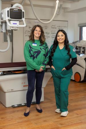 A RAD tech student and teacher pose by xray equipment