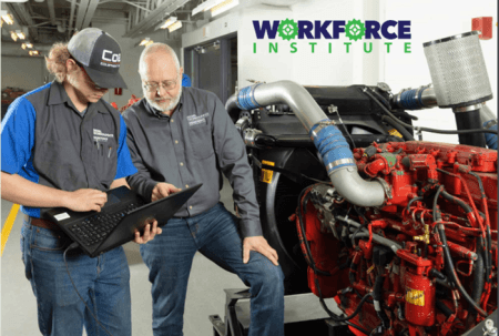 Workforce Institute at LLCC. Jeff Gardener talking to student holding a laptop, Next to them is a diesel engine.