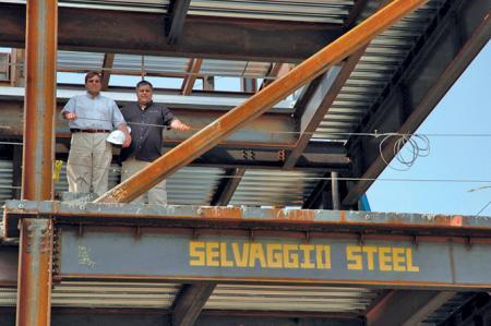 Selvaggio Steel - two men standing on second level of metal frame of building