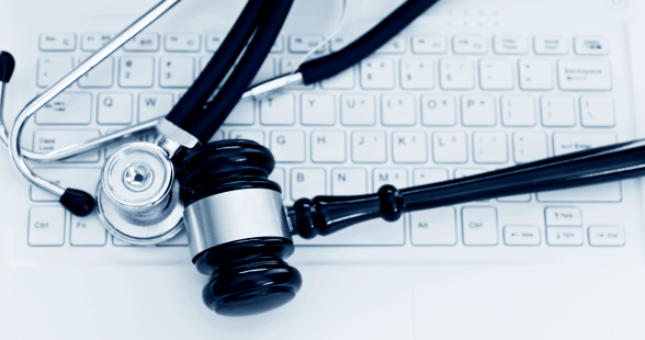 stethoscope and gavel laying on computer keyboard