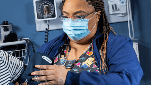 Medical assistant taking patient's blood pressure