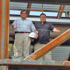Selvaggio Steel - two men standing on metal frame of building