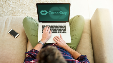 man on laptop with CareerStep logo on the computer screen