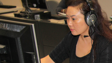 Woman wearing headset and working on a computer