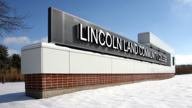 The Lincoln Land Community College entrance sign shown in winter with snow on the ground.