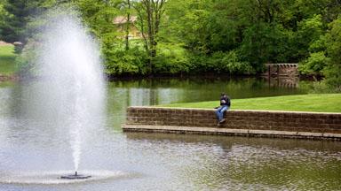 Student sitting by Lake Macoupin on LLCC's campus