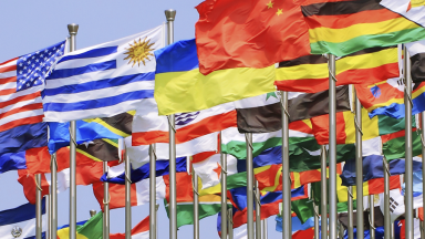 Multicolored flags from various countries blowing in the wind.